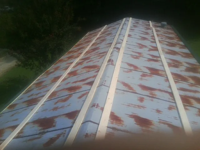 Rusted metal roof panels with new wood purlins before replacement — Storm Damage Roof Repair in Hixson by Roofing Brothers