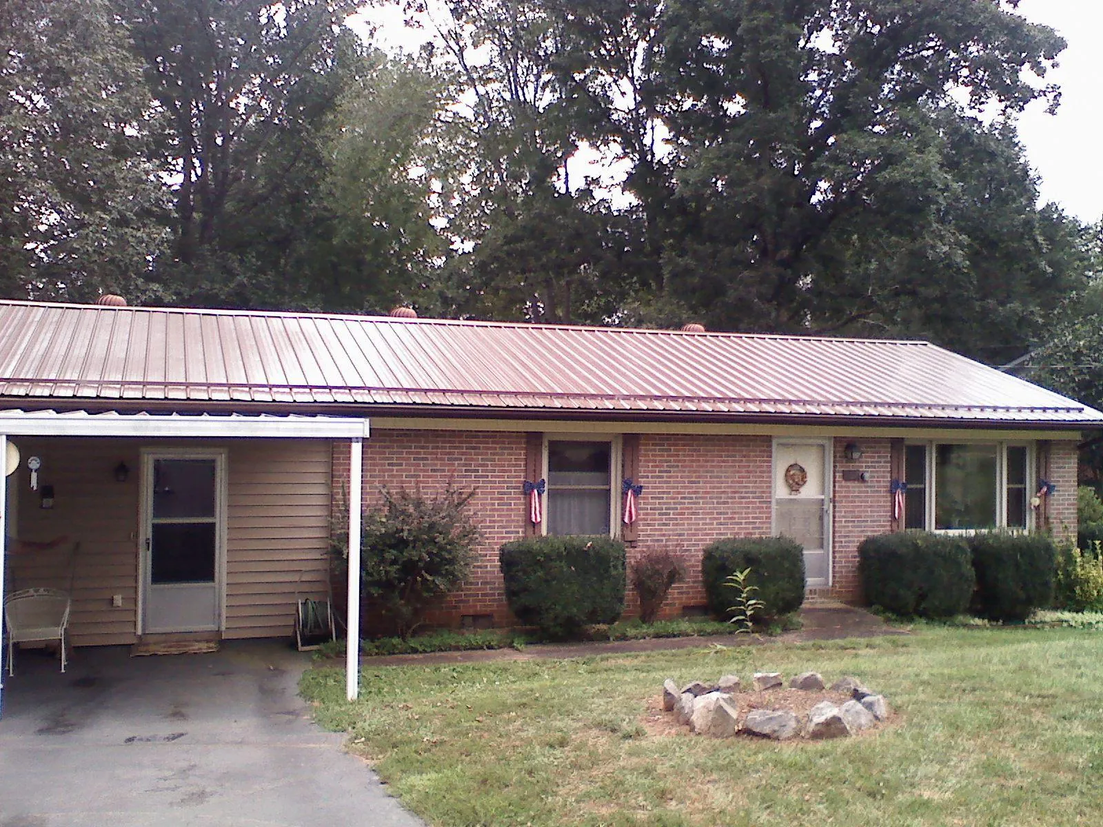 Bronze metal roof and carport on a brick ranch home — Roof Repair work by our crew in Hixson